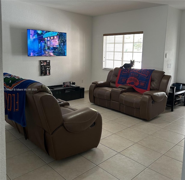 living room featuring light tile patterned floors and a textured wall