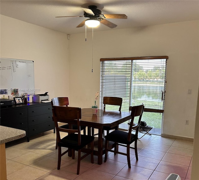 dining room featuring ceiling fan, baseboards, and light tile patterned flooring