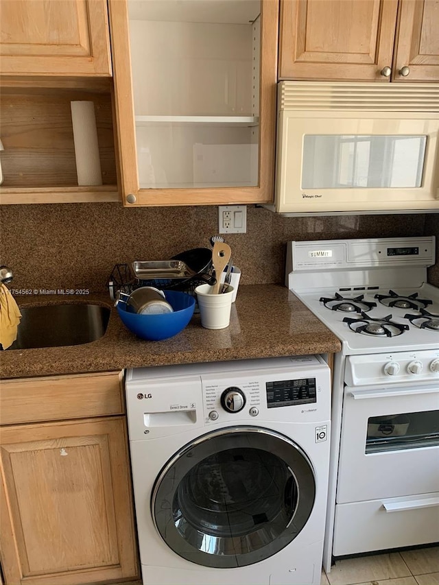 kitchen with open shelves, decorative backsplash, dark stone countertops, washer / dryer, and white appliances