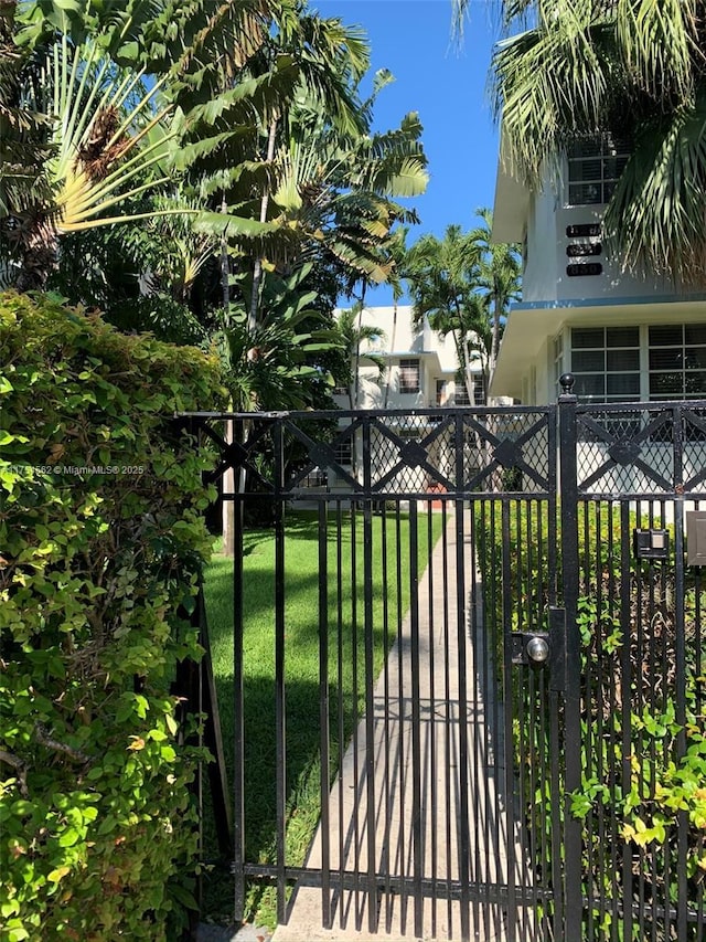 view of gate featuring a lawn and fence