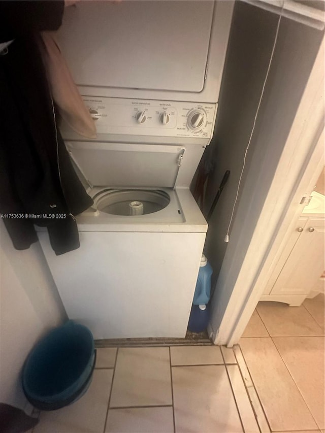 clothes washing area featuring laundry area, tile patterned flooring, and stacked washer / drying machine