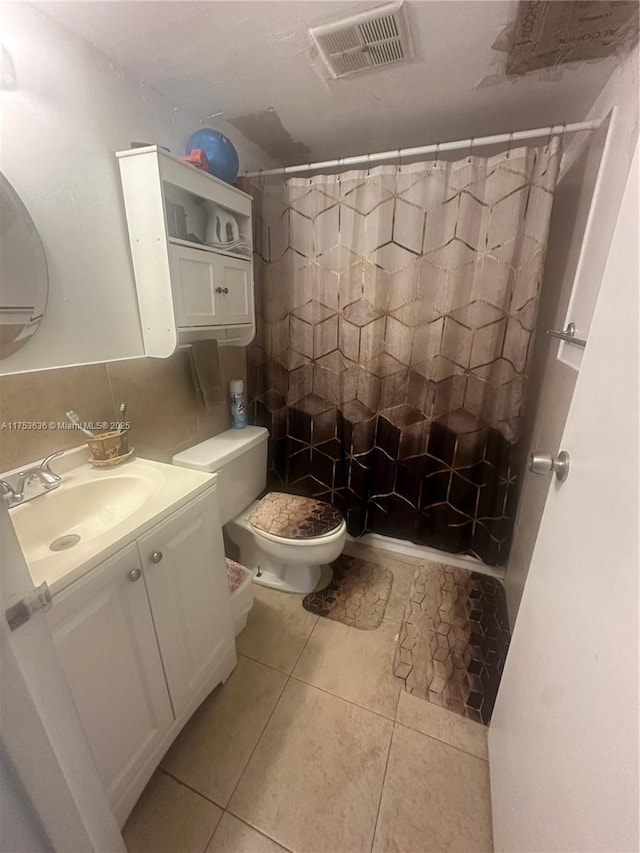 bathroom featuring toilet, a shower with shower curtain, vanity, visible vents, and tile patterned floors