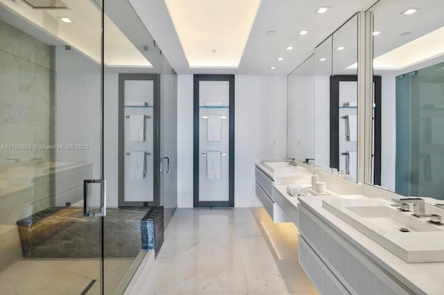 bathroom featuring a sink, double vanity, a stall shower, and a raised ceiling