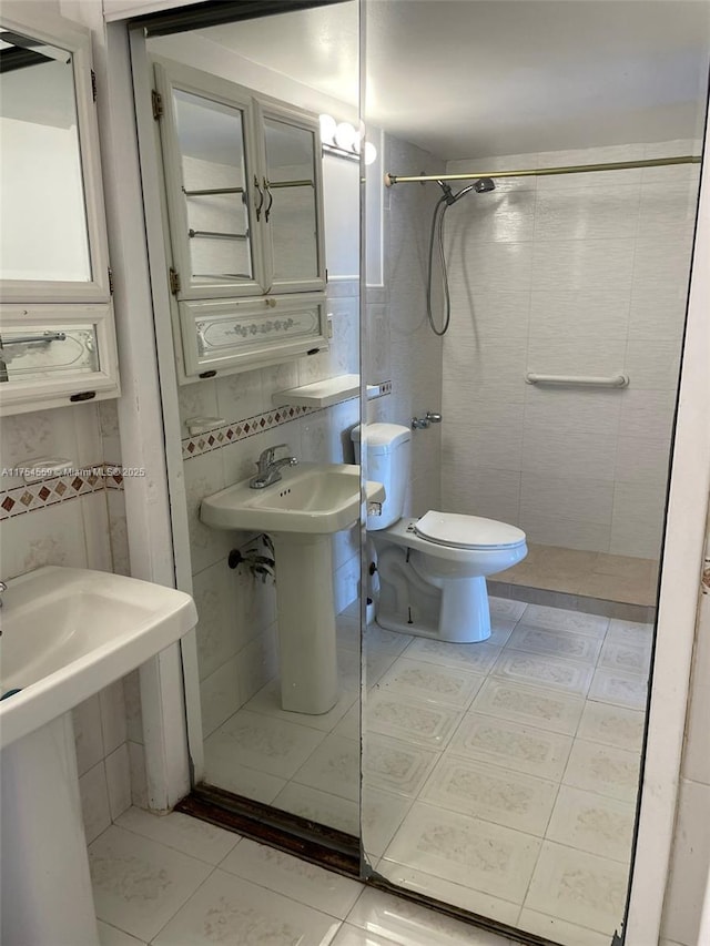 bathroom with tile patterned flooring, tiled shower, and tile walls