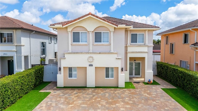 rear view of property featuring a tiled roof, french doors, fence, and stucco siding