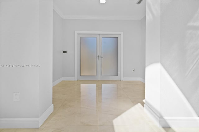 empty room with baseboards, ornamental molding, and french doors