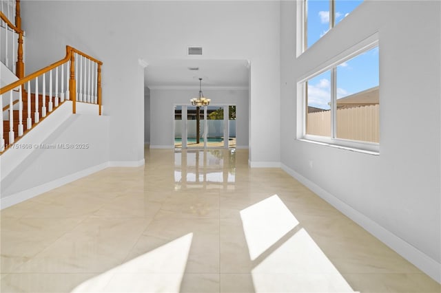 interior space with ornamental molding, an inviting chandelier, baseboards, and visible vents