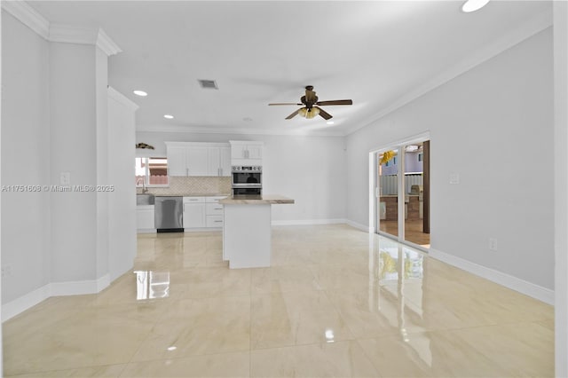 kitchen with decorative backsplash, ceiling fan, white cabinetry, ornamental molding, and appliances with stainless steel finishes