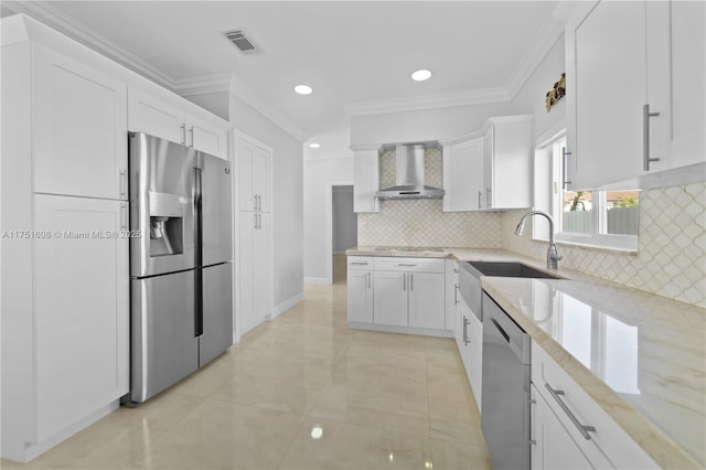 kitchen featuring white cabinets, wall chimney exhaust hood, ornamental molding, light stone countertops, and stainless steel appliances