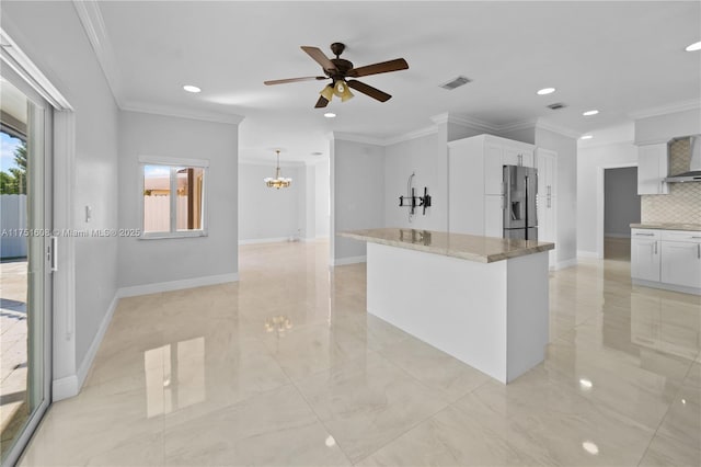 kitchen with stainless steel fridge, tasteful backsplash, visible vents, white cabinets, and ceiling fan with notable chandelier