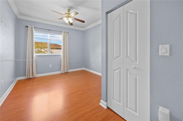 unfurnished bedroom featuring baseboards, light wood finished floors, and crown molding