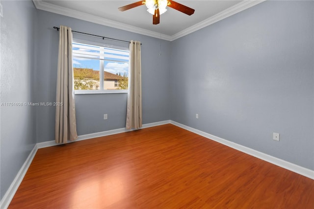spare room featuring wood finished floors, a ceiling fan, ornamental molding, and baseboards