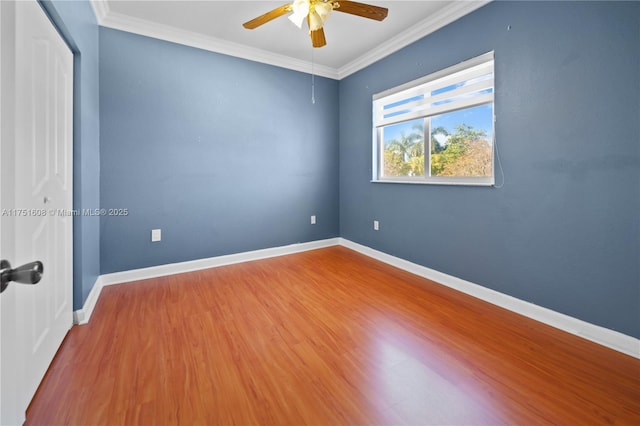 spare room featuring ornamental molding, baseboards, wood finished floors, and ceiling fan