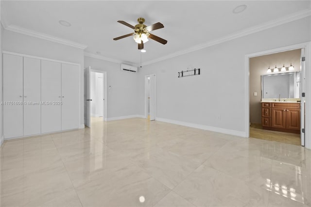 unfurnished bedroom with a wall unit AC, crown molding, a ceiling fan, ensuite bath, and baseboards