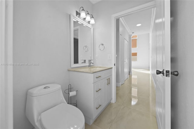 bathroom with vanity, toilet, baseboards, ornamental molding, and tile patterned flooring
