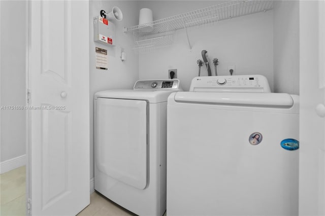 laundry area with light tile patterned floors, separate washer and dryer, and laundry area