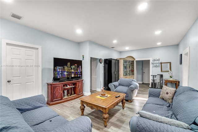 living area with light wood finished floors, visible vents, and recessed lighting