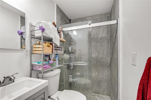 bathroom with toilet, a shower stall, and vanity