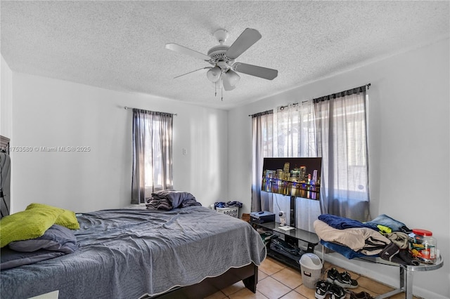 bedroom with a textured ceiling, ceiling fan, and light tile patterned flooring