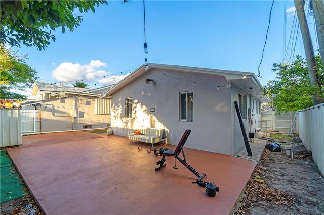 back of house featuring a patio, a fenced backyard, and stucco siding