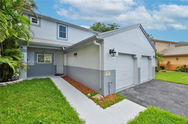 traditional home featuring driveway, a front lawn, an attached garage, and stucco siding