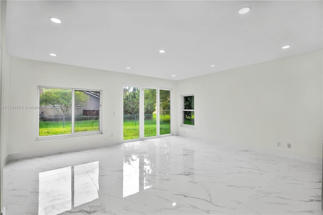 unfurnished room featuring recessed lighting and marble finish floor