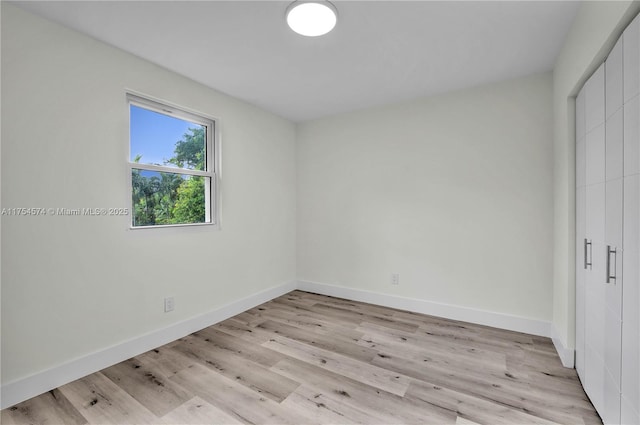 unfurnished bedroom with a closet, light wood-style flooring, and baseboards