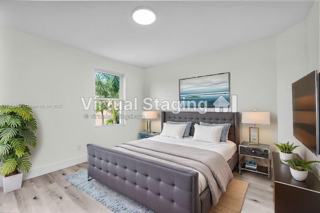 bedroom with baseboards and wood finished floors