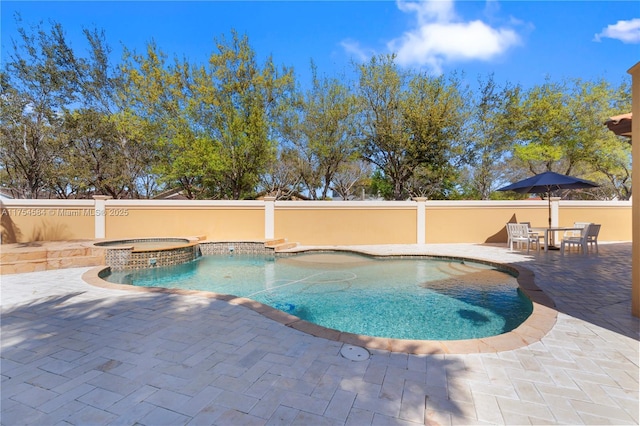 view of swimming pool featuring a patio area, a pool with connected hot tub, and fence