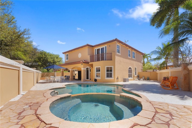 view of pool featuring a pool with connected hot tub, a patio area, and a fenced backyard