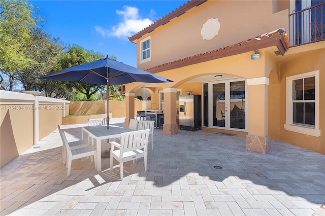 view of patio / terrace with french doors, outdoor dining space, and fence