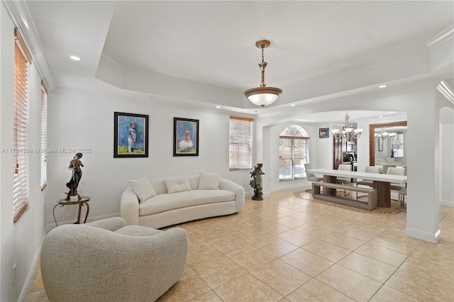 living area with ornamental molding, arched walkways, a raised ceiling, and recessed lighting