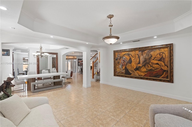 living room featuring stairway, a tray ceiling, arched walkways, and baseboards