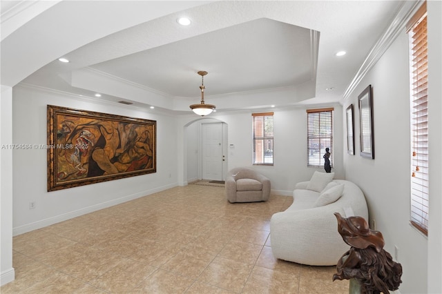 interior space with arched walkways, a tray ceiling, recessed lighting, ornamental molding, and baseboards