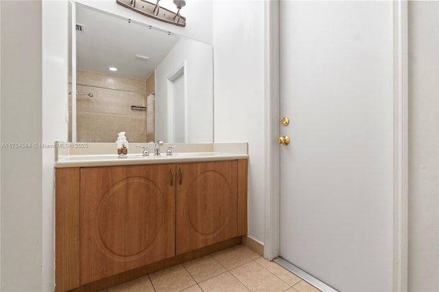 bathroom with vanity, a tile shower, and tile patterned floors