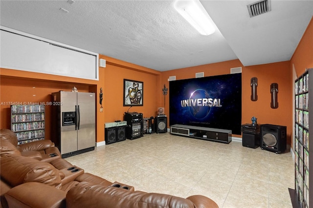 cinema room with visible vents and a textured ceiling