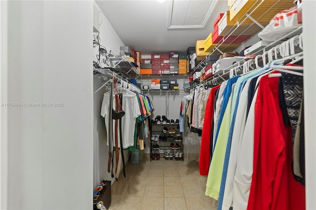 spacious closet with attic access and tile patterned floors