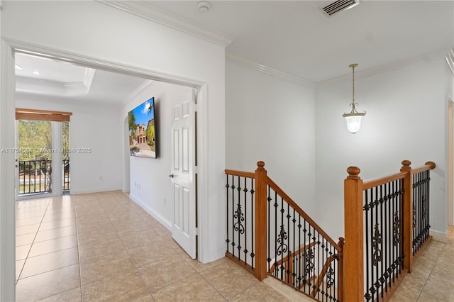 hall featuring baseboards, visible vents, crown molding, and an upstairs landing