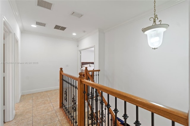 hallway with ornamental molding, baseboards, visible vents, and an upstairs landing