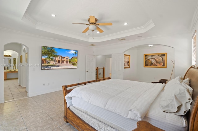 bedroom with arched walkways, a tray ceiling, light tile patterned flooring, and crown molding