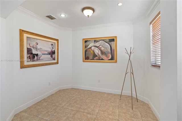 spare room with crown molding, light tile patterned floors, visible vents, and baseboards