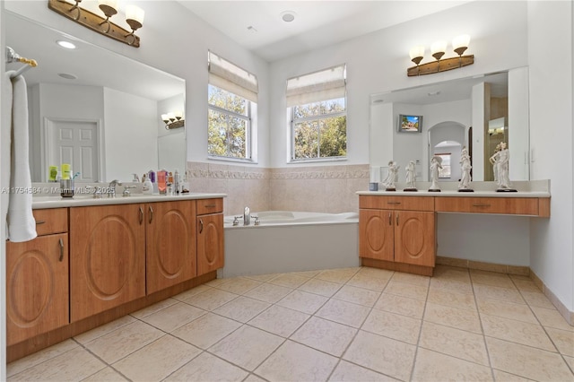 full bathroom with two vanities, a sink, a bath, and tile patterned floors