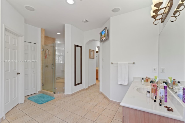 bathroom with a stall shower, visible vents, vanity, and tile patterned floors