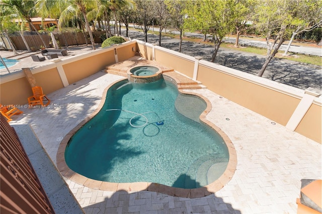 view of pool with an in ground hot tub, a patio, fence, and a fenced in pool