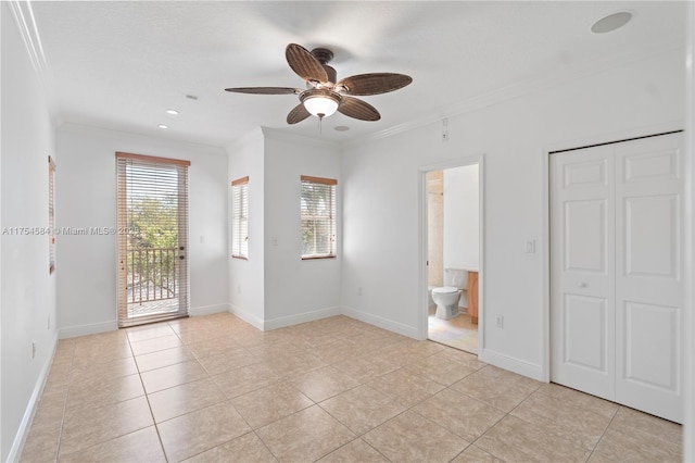 interior space with light tile patterned floors, baseboards, connected bathroom, ornamental molding, and access to outside