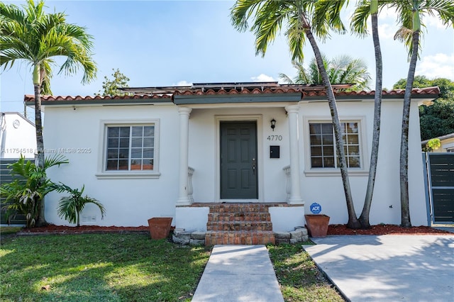 mediterranean / spanish home featuring stucco siding and a front yard