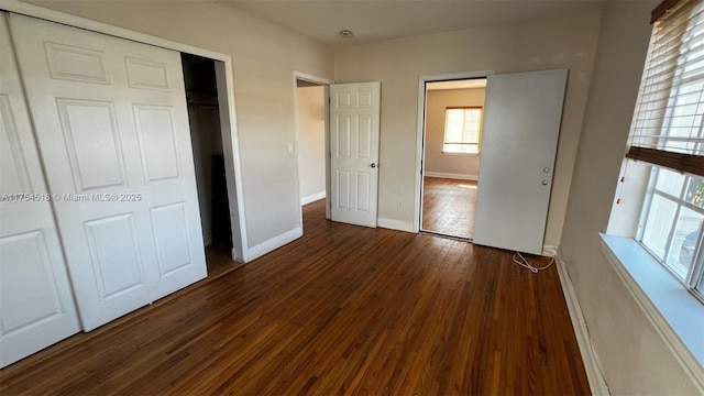 unfurnished bedroom featuring a closet, baseboards, and wood finished floors