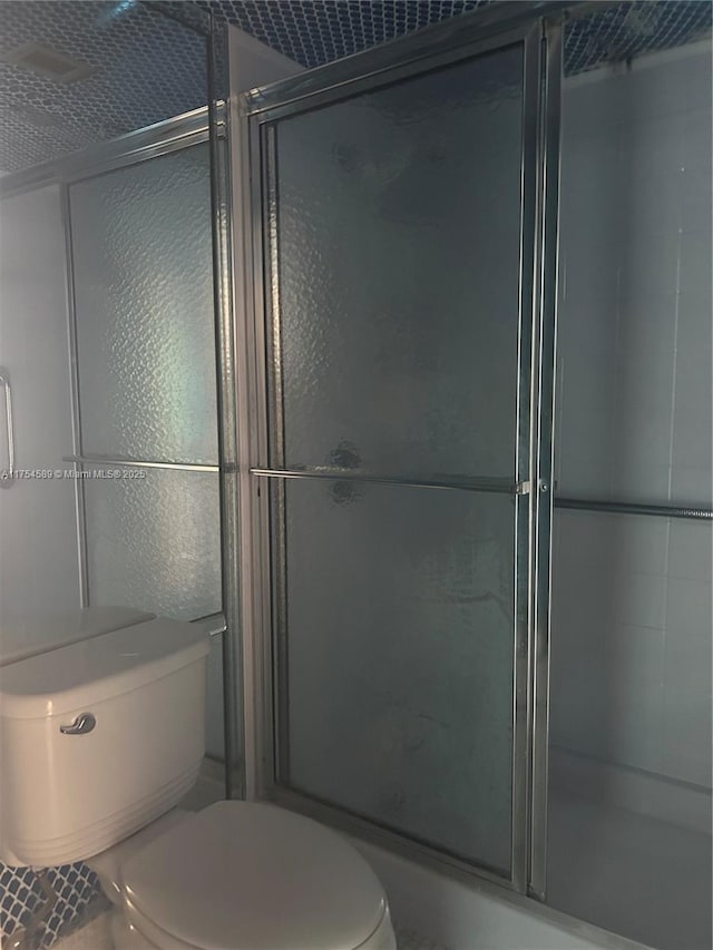 bathroom featuring a shower stall and toilet