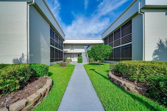 view of community featuring stairs and a lawn