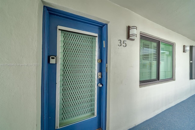 property entrance with stucco siding